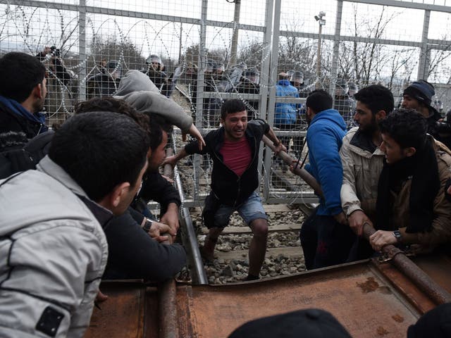 Refugees attempt to break through the border fence