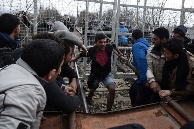 Refugees attempt to break through the border fence