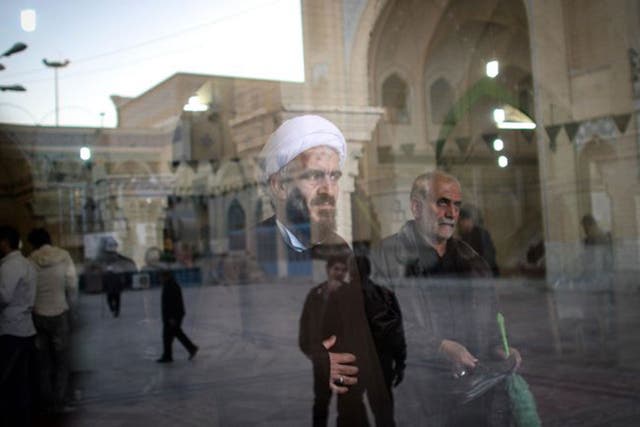 A cleric waits to cast his ballot papers at a polling station in Qom, during elections for Iran’s parliament, the Majlis, and the Assembly of Experts