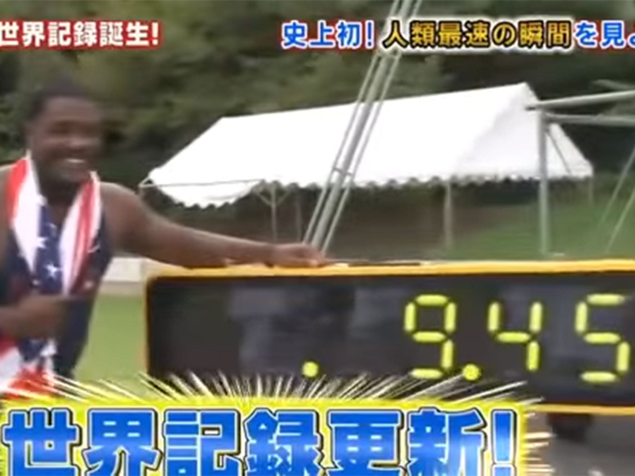 Justin Gatlin poses next to the time