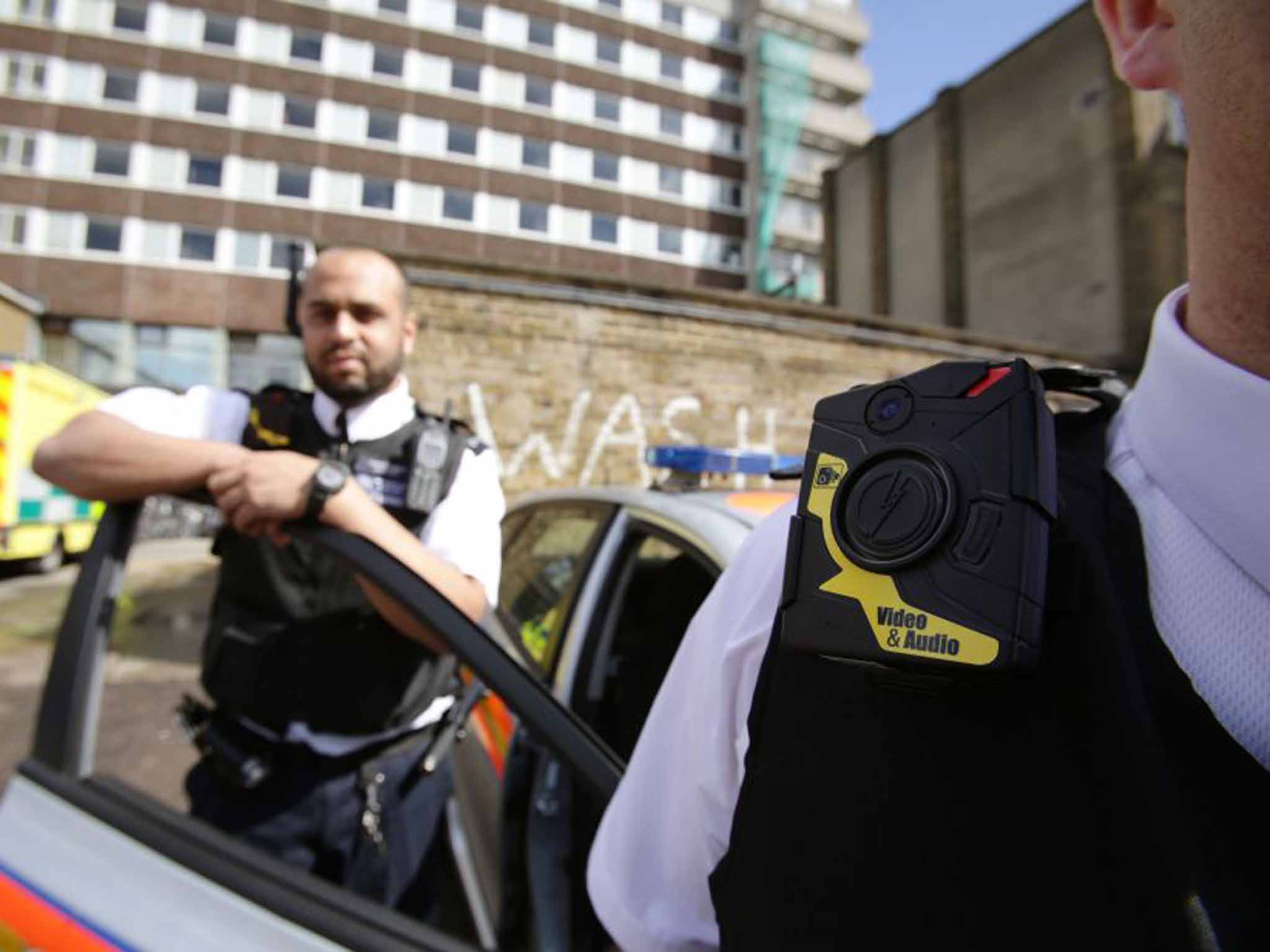 Watching the watchmen: Metropolitan Police Constable Yasa Amerat and a colleague show off body-worn video (BWV) cameras