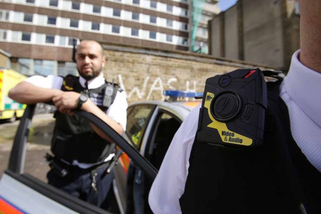 Watching the watchmen: Metropolitan Police Constable Yasa Amerat and a colleague show off body-worn video (BWV) cameras