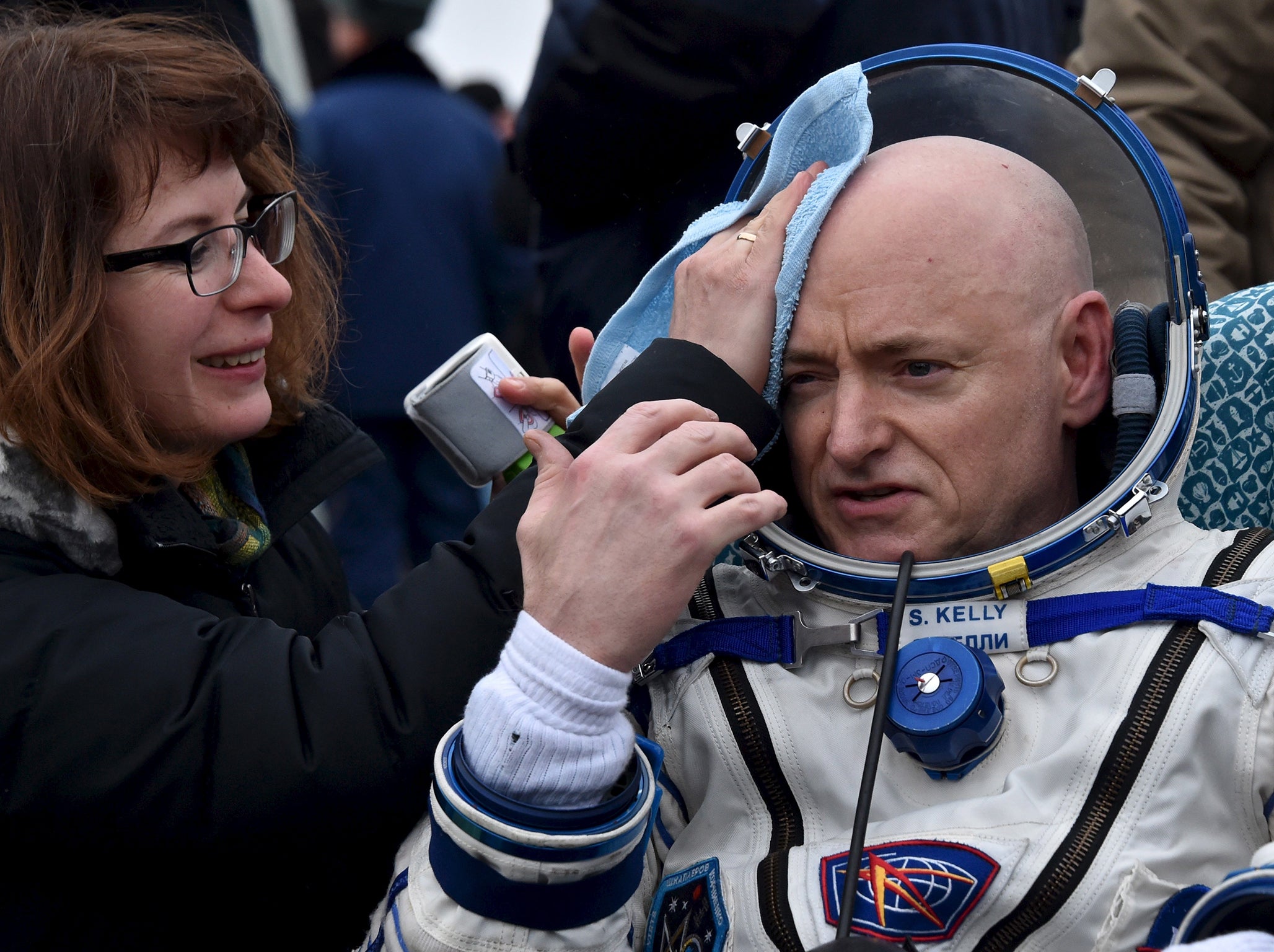 U.S. astronaut Scott Kelly is assisted by ground personnel shortly after landing near the town of Dzhezkazgan