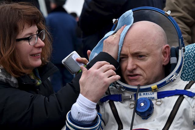 U.S. astronaut Scott Kelly is assisted by ground personnel shortly after landing near the town of Dzhezkazgan