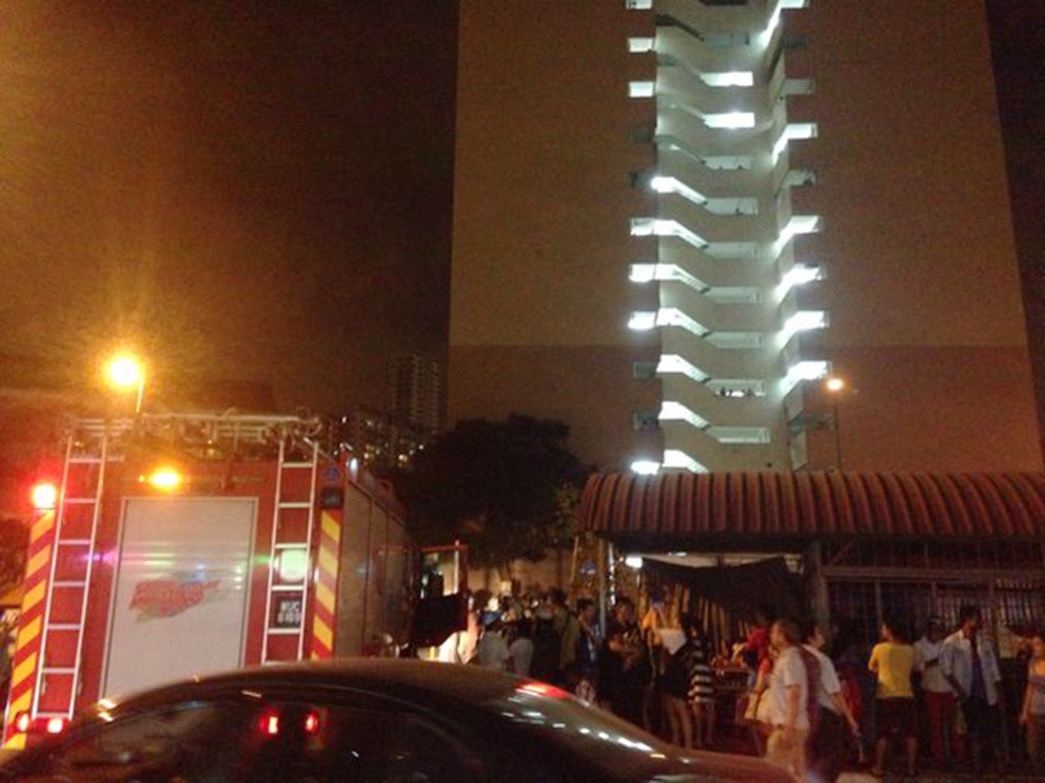 People gather outside a high-rise building in Kuala Lumpur, Malaysia