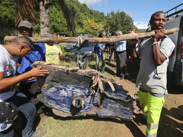 Local ecological association members and volunteers carry debris found on France's Reunion Island, last August