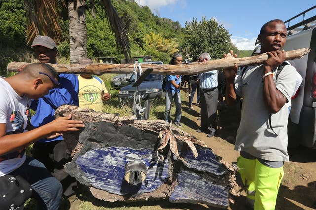 Local ecological association members and volunteers carry debris found on France's Reunion Island, last August