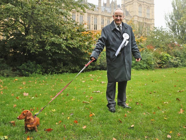 Laurence Robertson, Conservative MP for Tewkesbury stands in front of The Houses of Parliament with his dog, Sausage