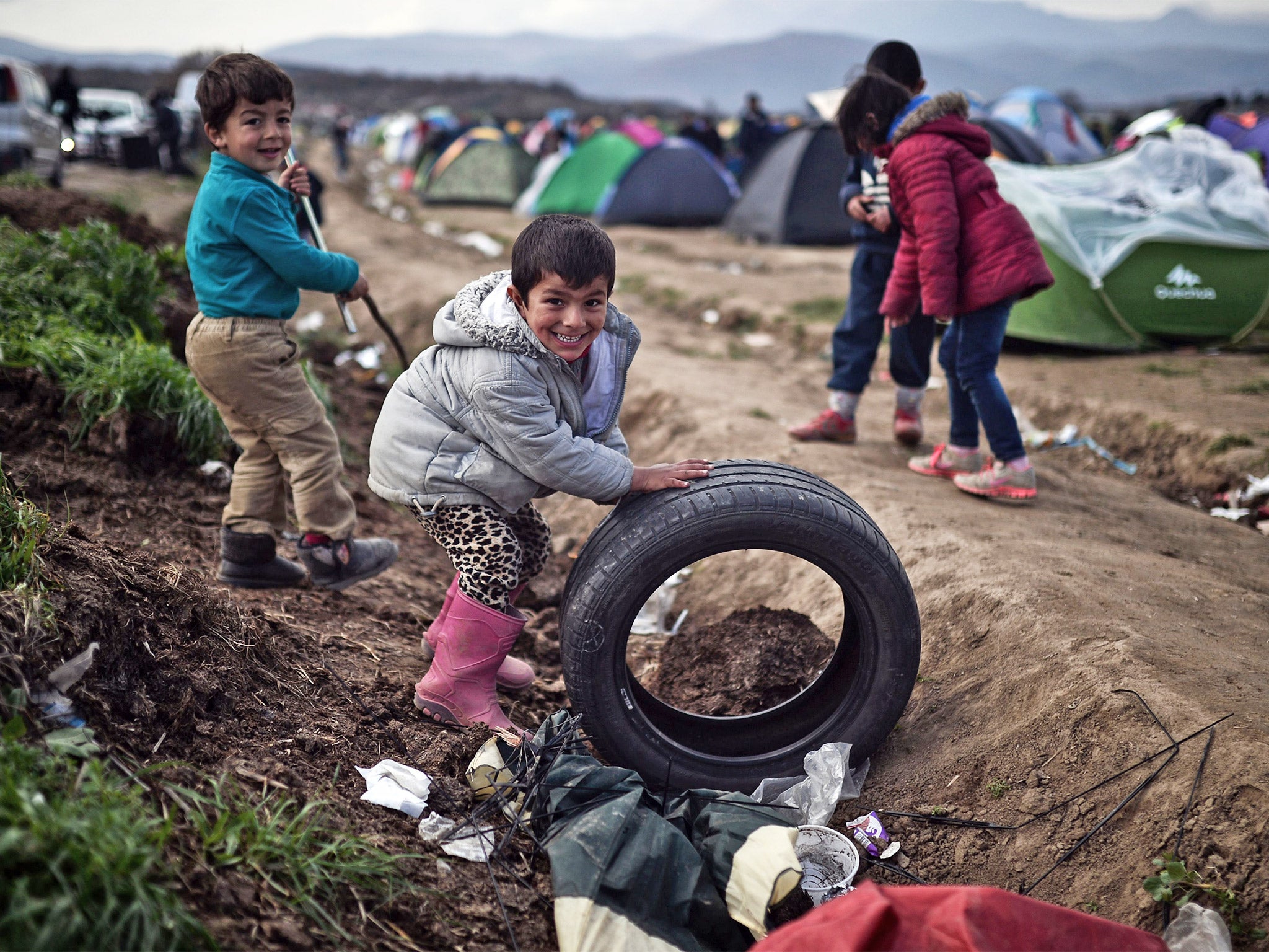 Refugee children play in a makeshift camp at the Greek-Macedonian border