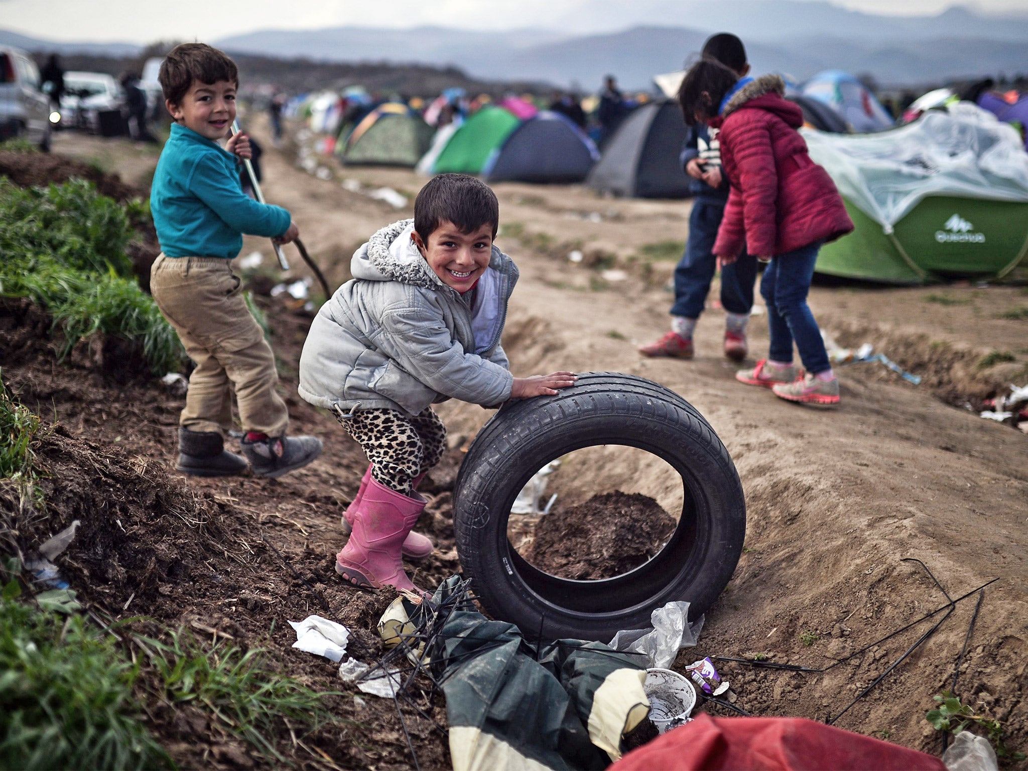 Children play in a makeshift refugee camp at the Greek-Macedonian border