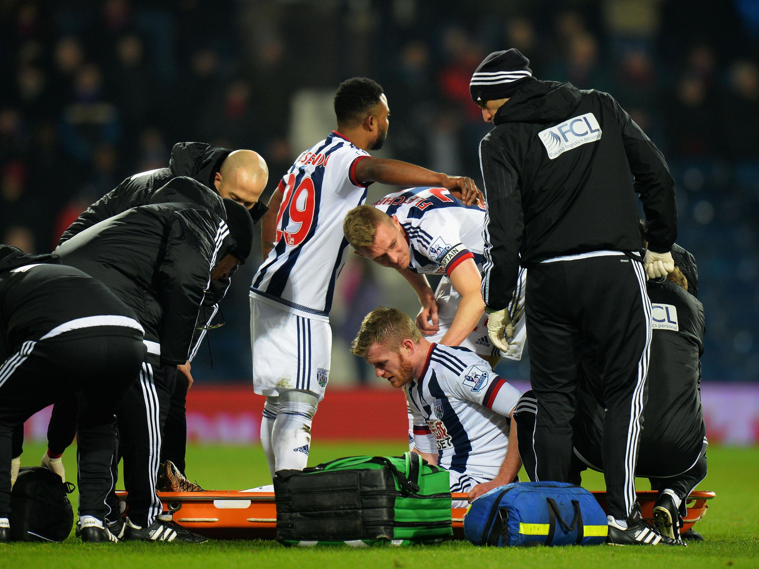 Chris Brunt receives treatment after falling awkwardly