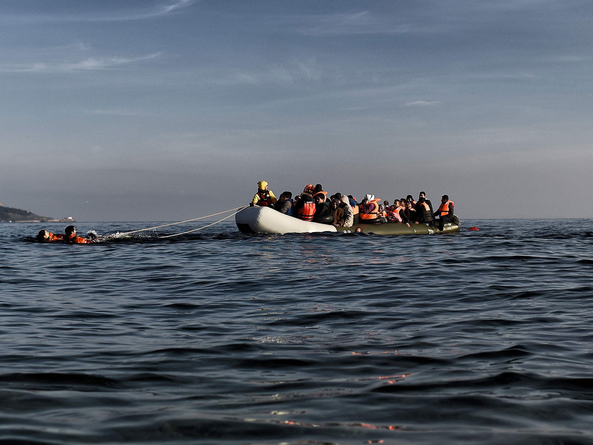 Migrants arrive on a rubber boat in Mytilene, on the Greek island of Lesbos, after crossing the Aegean sea from Turkey