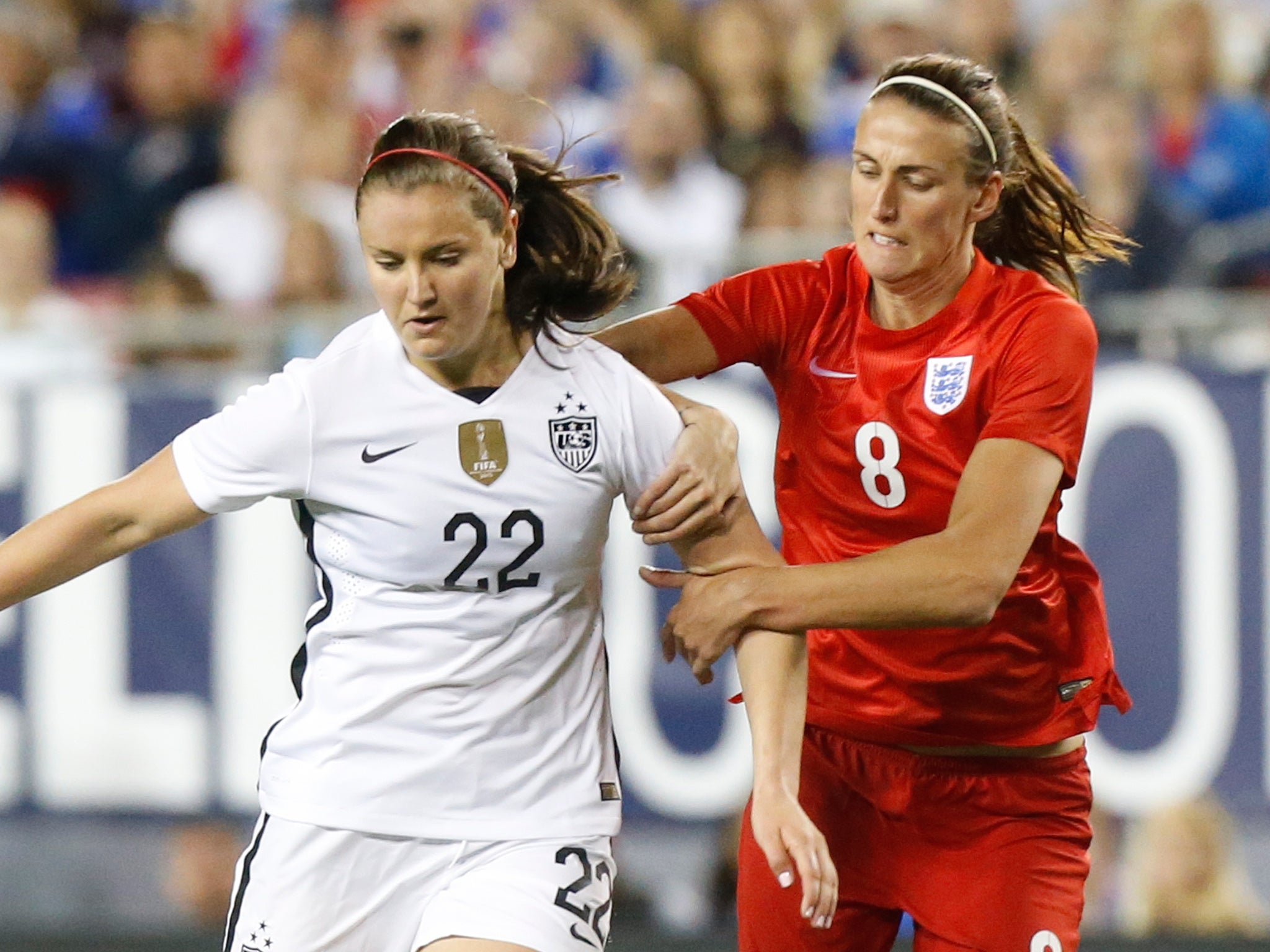 Lindsey Horan and Jill Scott compete for the ball