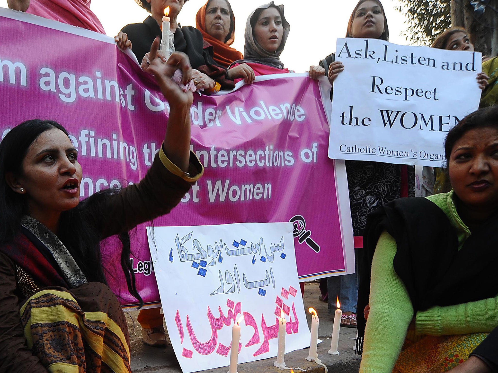 Pakistani women pose with candles to mark the International Day for the Elimination of Violence against Women in Lahore