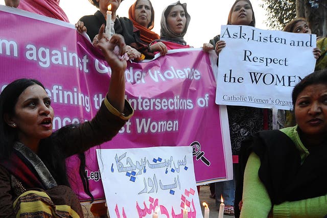 Pakistani women pose with candles to mark the International Day for the Elimination of Violence against Women in Lahore on November 25, 2010.