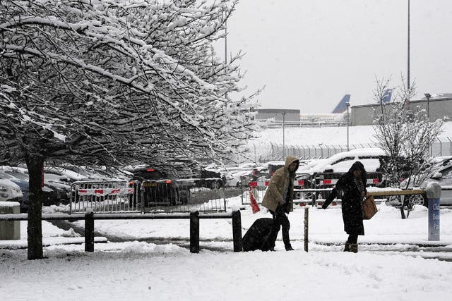 Passengers make their way through the snow to Leeds Bradford Airport which was forced to close while crews worked to clear the runway, as parts of the UK woke up to almost four inches of snow on Friday morning as March continues to feel more like winter than spring.