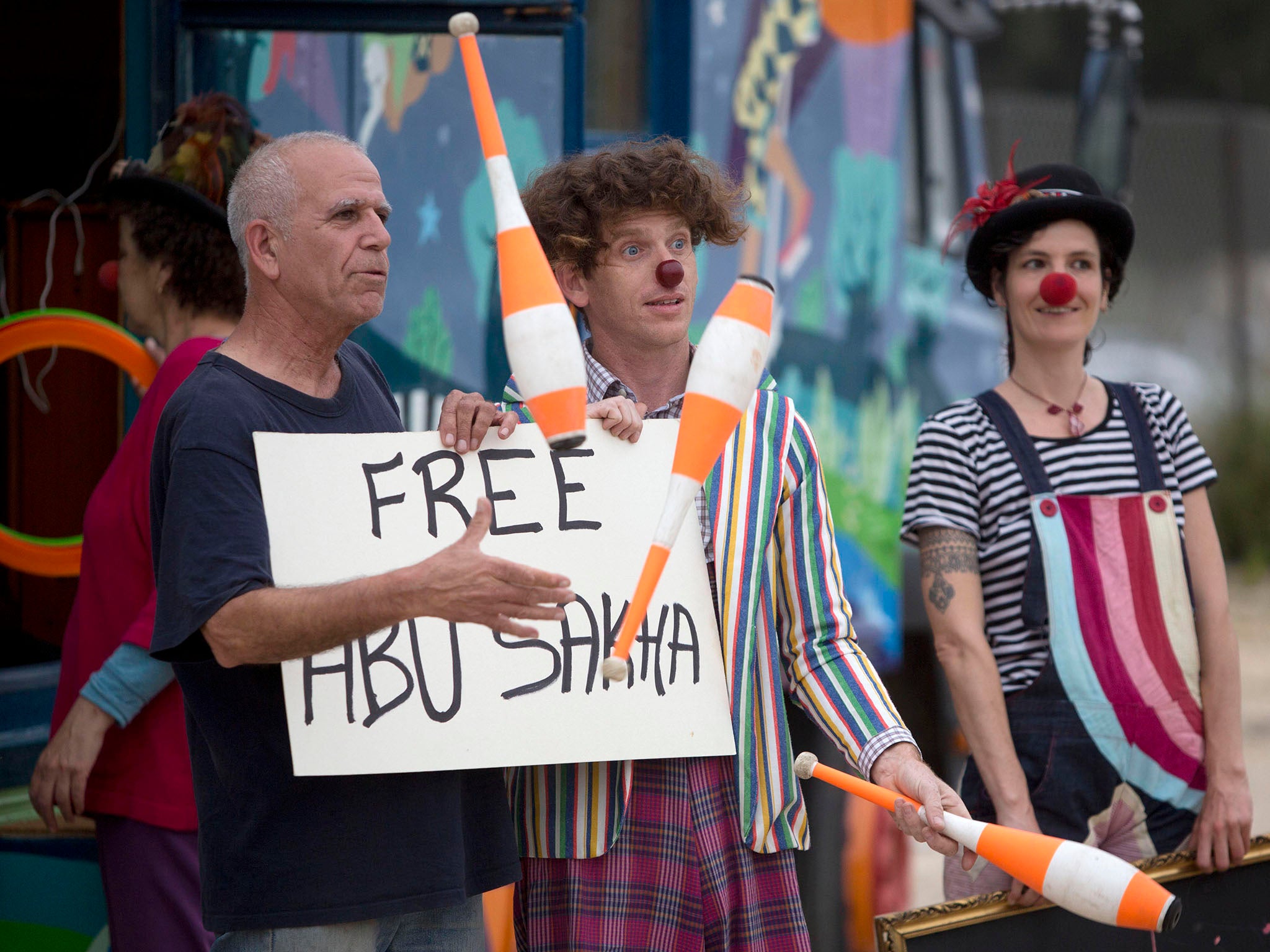 Clowns protest outside the Israeli prison where it is believed Mr Sakha is being held