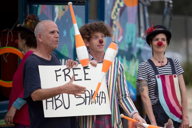 Clowns protest outside the Israeli prison where it is believed Mr Sakha is being held