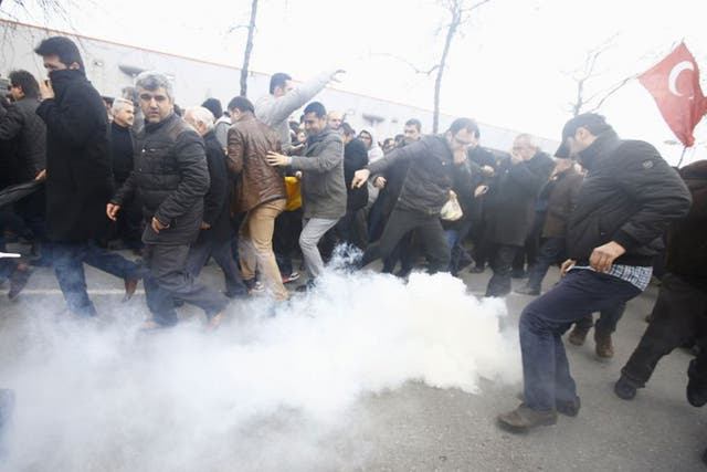 Riot police use tear gas to disperse protesting employees and supporters of Zaman newspaper at the courtyard of the newspaper's office in Istanbul, Turkey.