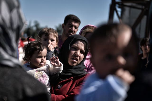 A mother and her child with aid workers in Idomeni