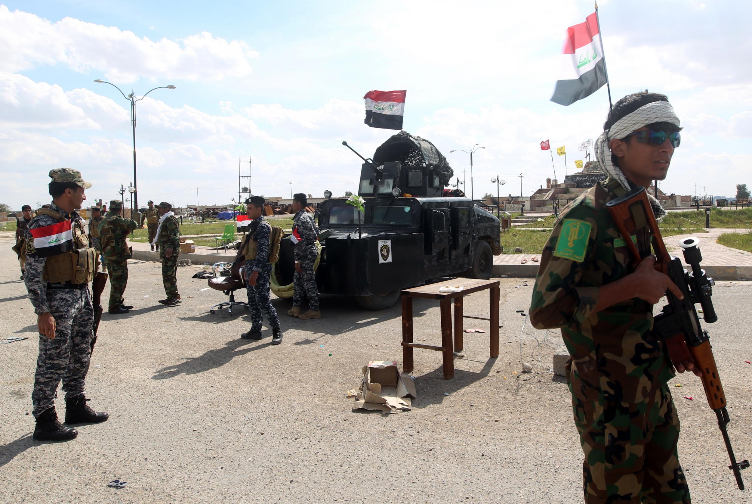 Iraqi policemen stand at a checkpoint in March 2015