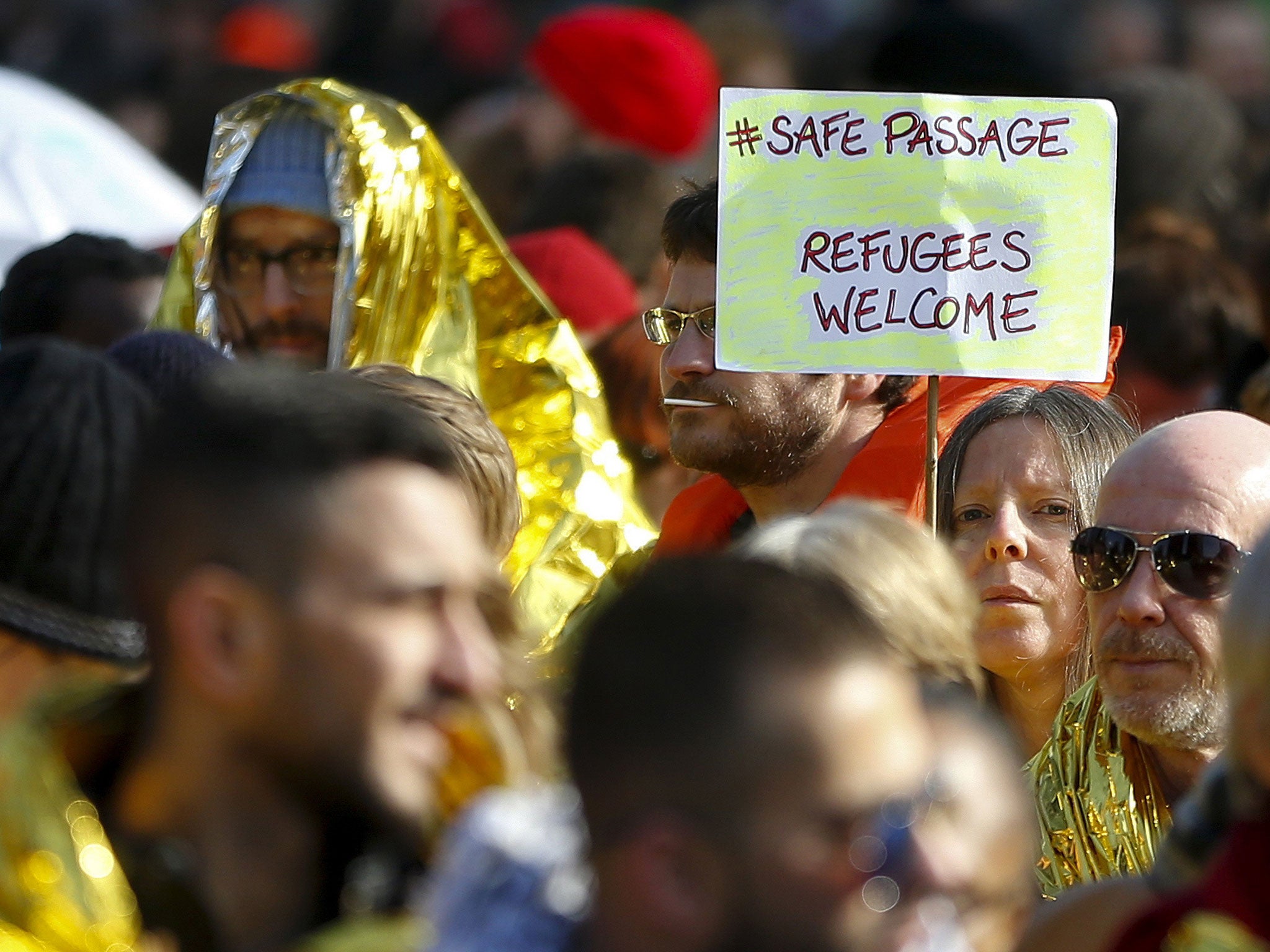 People taking part in a rally asking for a change in the refugee policy in Europe as part of an international initiative in favour of better living conditions of migrants, in Brussels, Belgium