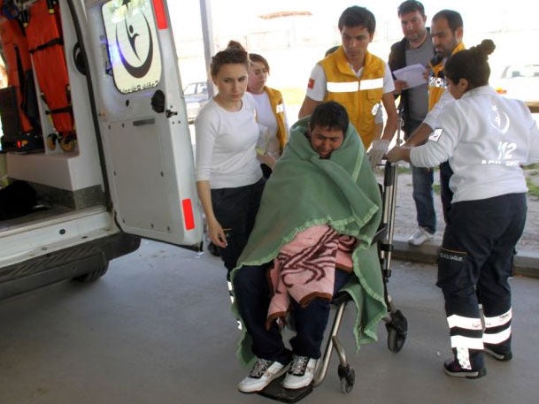 Medics take care of a rescued migrant at a local hospital in the Aegean resort of Didim, Turkey