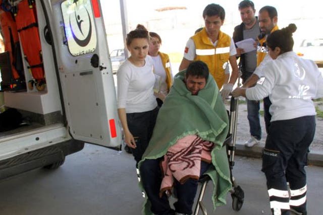 Medics take care of a rescued migrant at a local hospital in the Aegean resort of Didim, Turkey