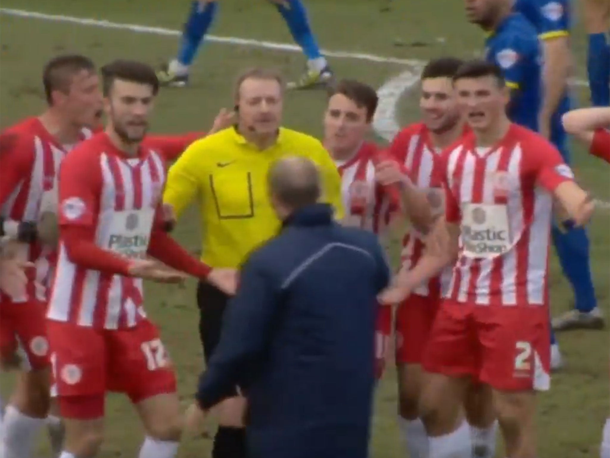 The Accrington players surround the referee to protest as manager John Coleman attempts to calm them