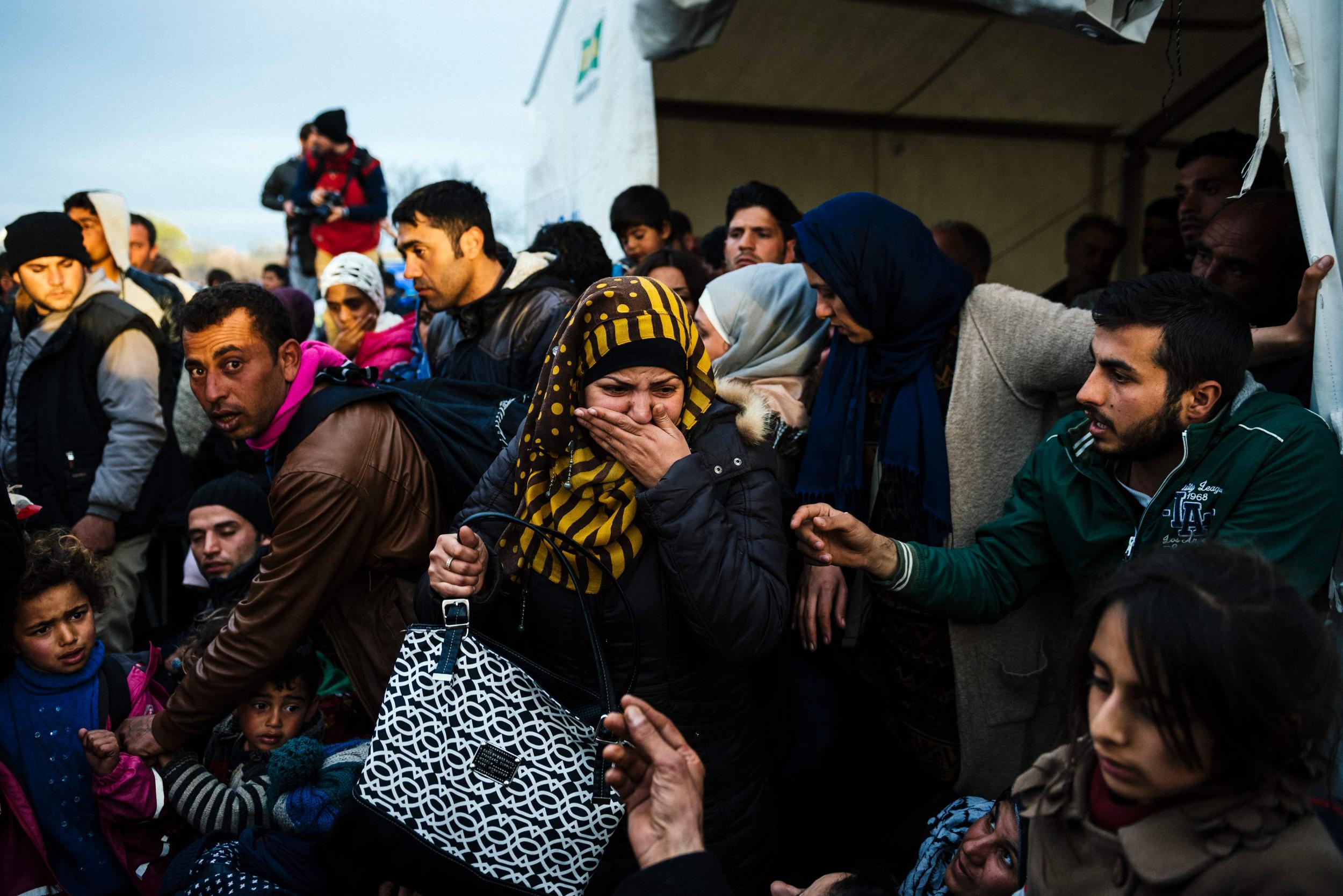 A woman reacts after losing sight of her child near the gate at the Greek-Macedonian border
