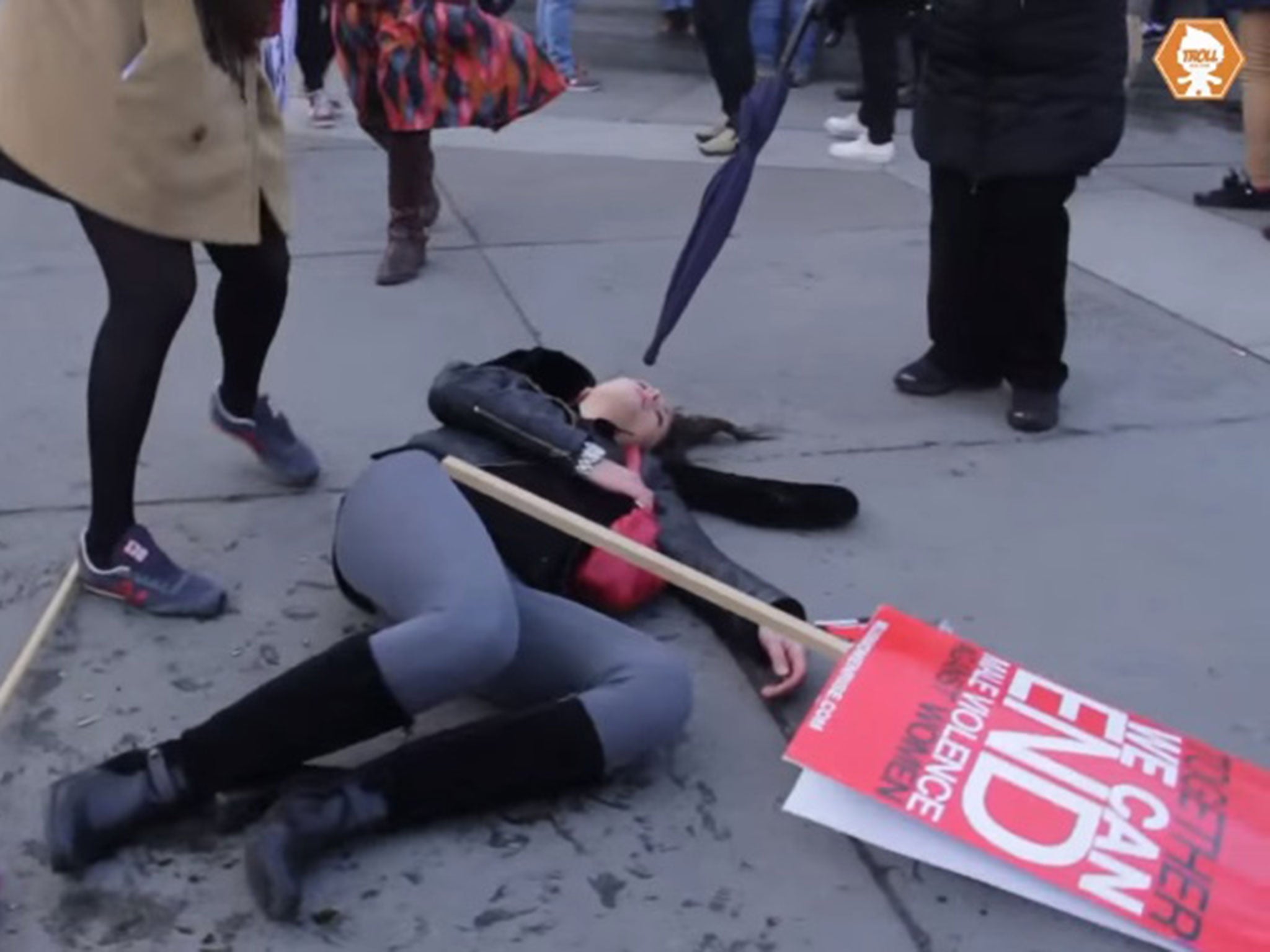 A woman appeared to be hit with a glass bottle by a man at a women's rally in London's Trafalgar Square