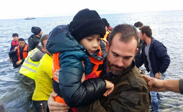 Dr Xand van Tulleken helping refugees out of a boat in Lesbos