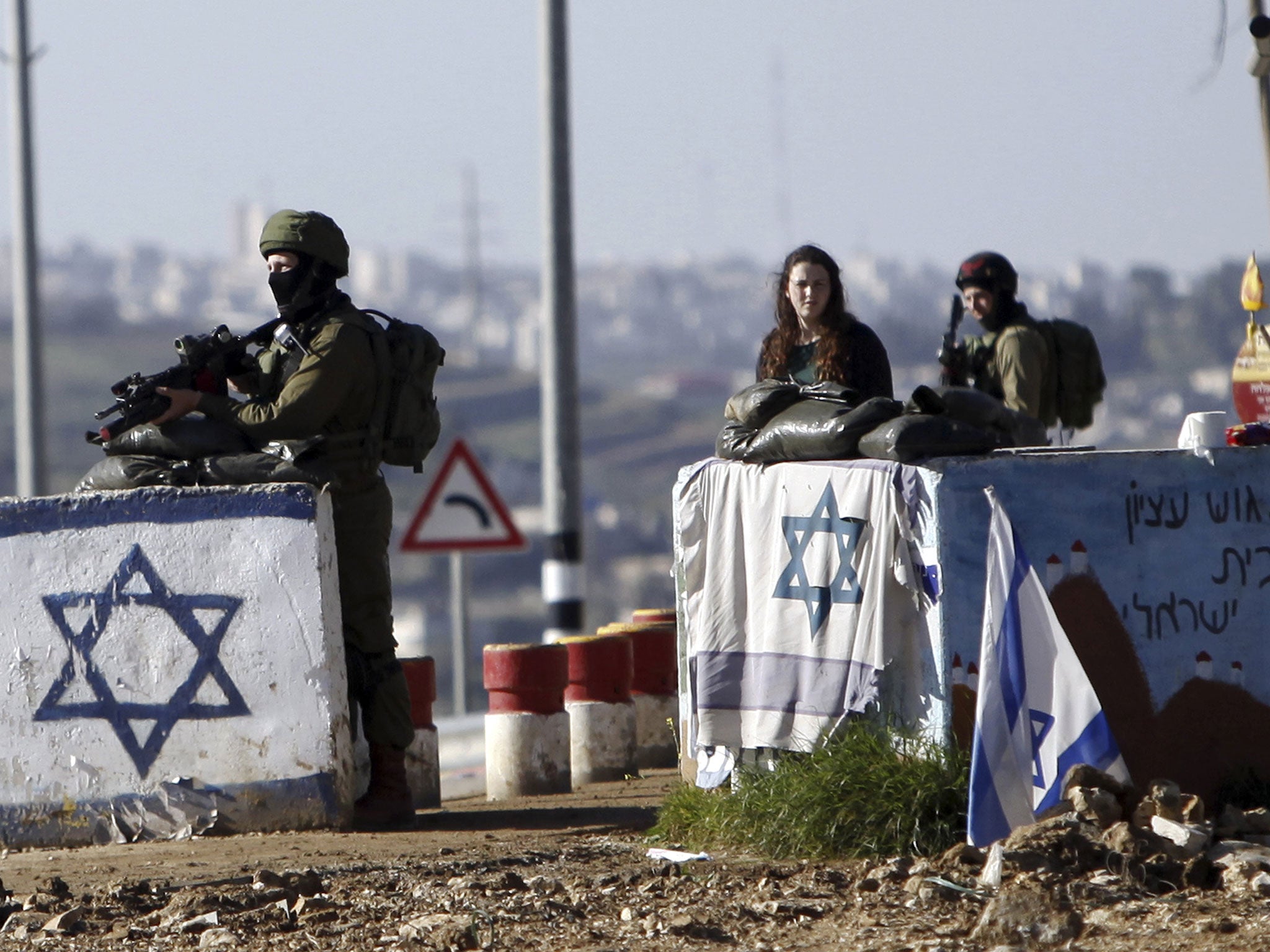 Israeli soldiers stand guard at Gush Etzion junction in the West Bank Friday, March 4, 2016, after a Palestinian woman allegedly tried to run over a soldier with her car. 