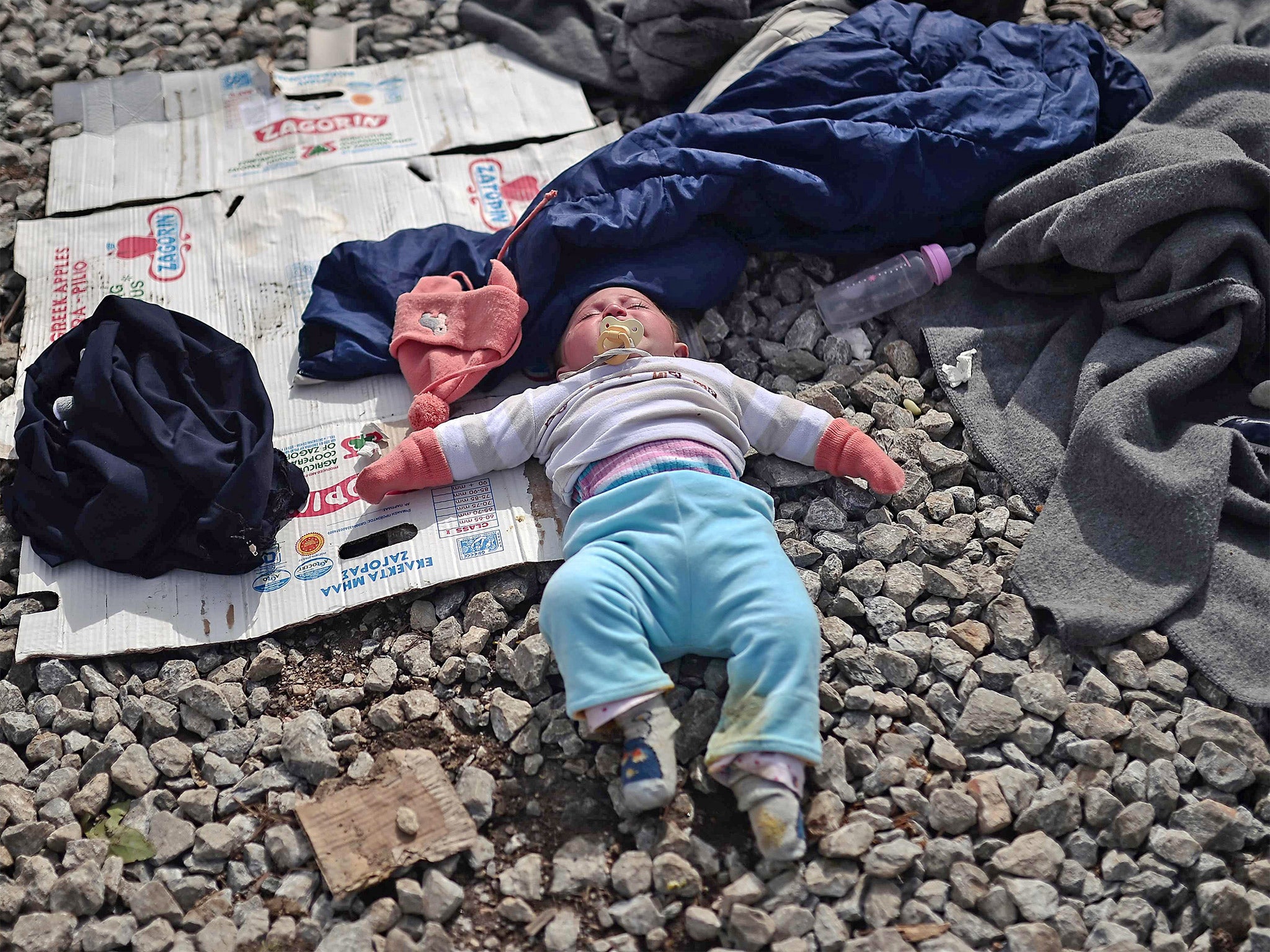 A baby sleeps near railway tracks at the makeshift camp near the village of Idomeni on the Greek-Macedonian border, where thousands of refugees and migrants are stranded (Getty)