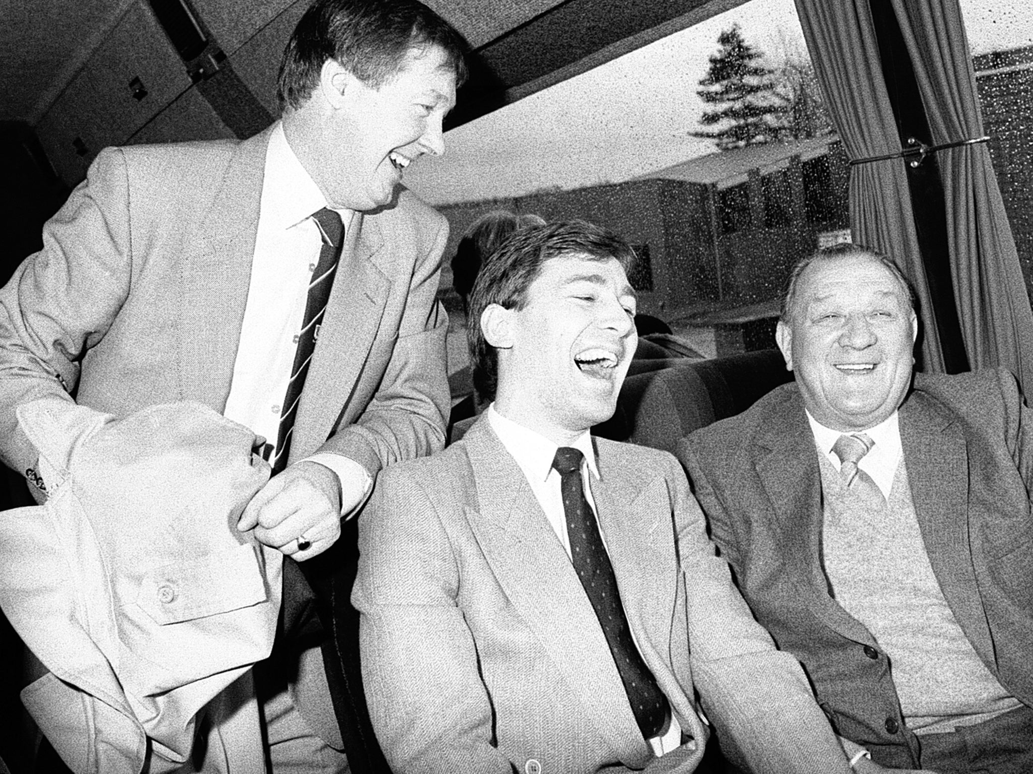 Bob Paisley (right), the former Liverpool manager, shares a joke with Bryan Robson (centre) and Alex Ferguson (left) on the United team coach travelling to Anfield on Boxing Day 1986
