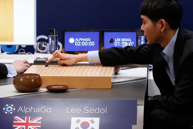 South Korean professional Go player Lee Sedol, right, puts the first stone against Google's artificial intelligence program, AlphaGo, during the Google DeepMind Challenge Match in Seoul, South Korea