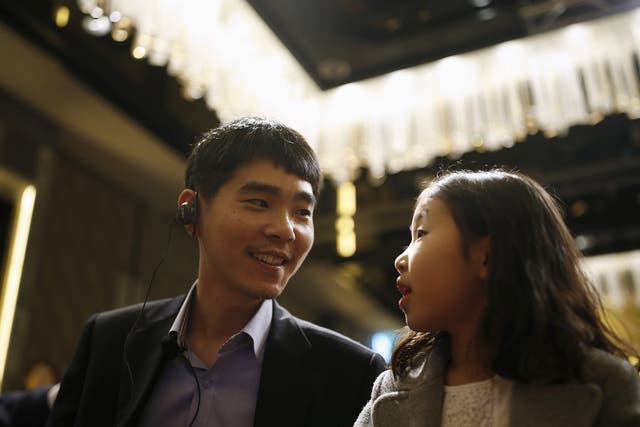 South Korea’s Lee Sedol, the world’s top Go player, talks with his daughter during a news conference ahead of matches against Google’s artificial intelligence program AlphaGo, in Seoul, South Korea, March 8, 2016