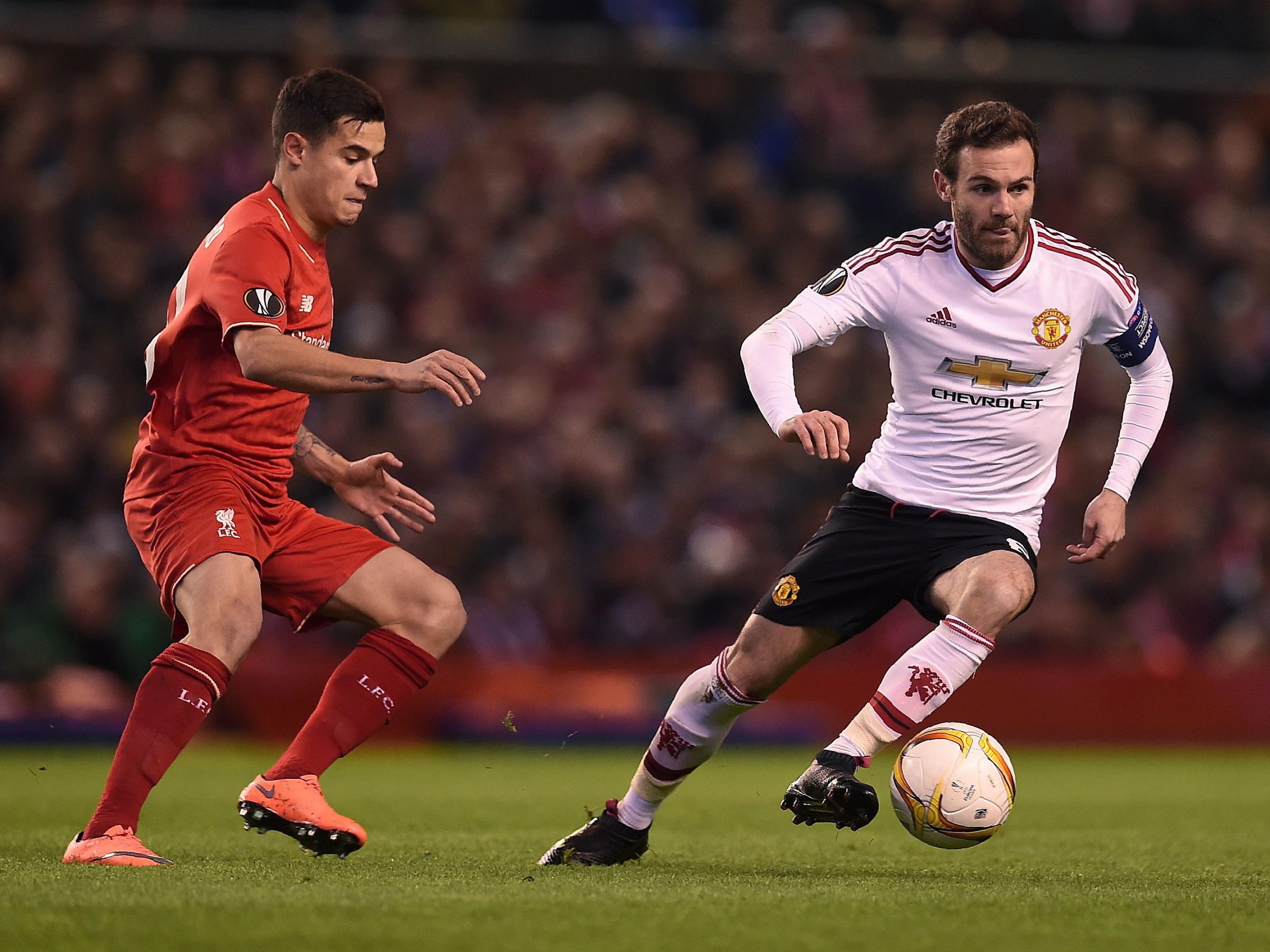 Juan Mata and Philippe Coutinho jostle for possession during the Europa League clash between Liverpool and Manchester United