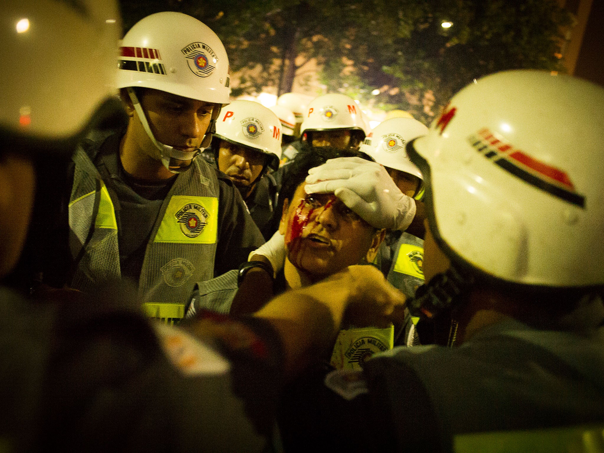 A female police officer injured by a stone thrown by protesters is helped by her colleagues, Sao Paulo, May 2014 © André Liohn/Prospekt