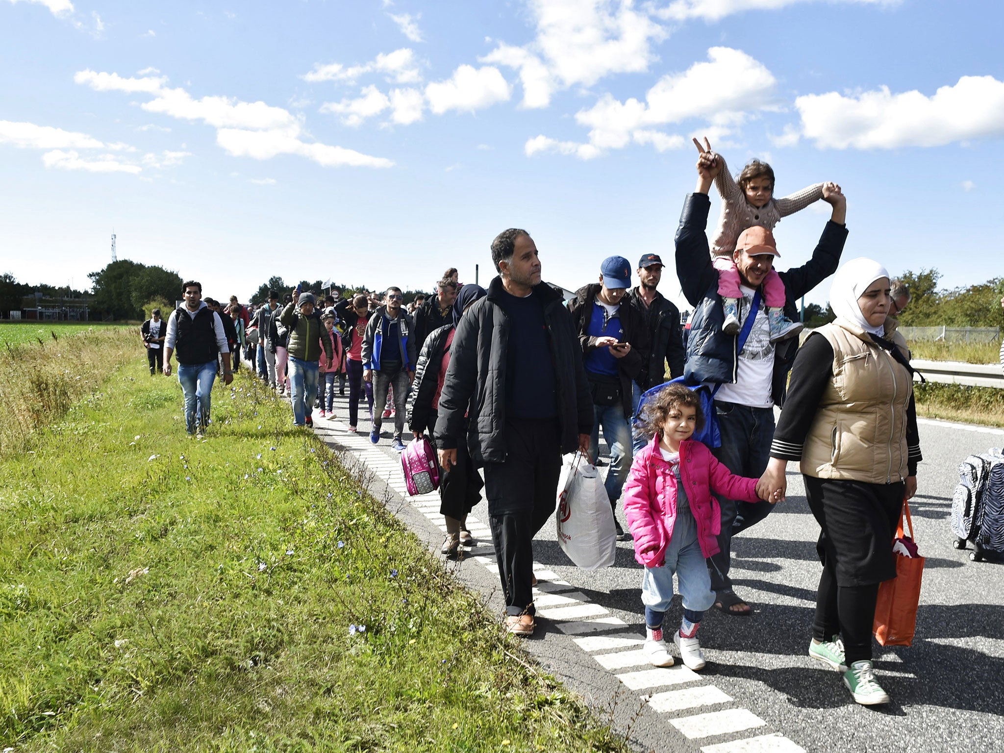 Migrants, mainly from Syria, walk on the highway 12km north of Rodby, Denmark moving to the north on September 7, 2015.