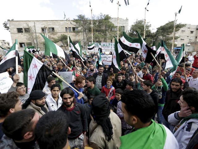 Protesters carry Free Syria Army flags and shout slogans during an anti-government protest after Friday prayers in the town of Marat Numan in Idlib province, Syria, March 11, 2016.