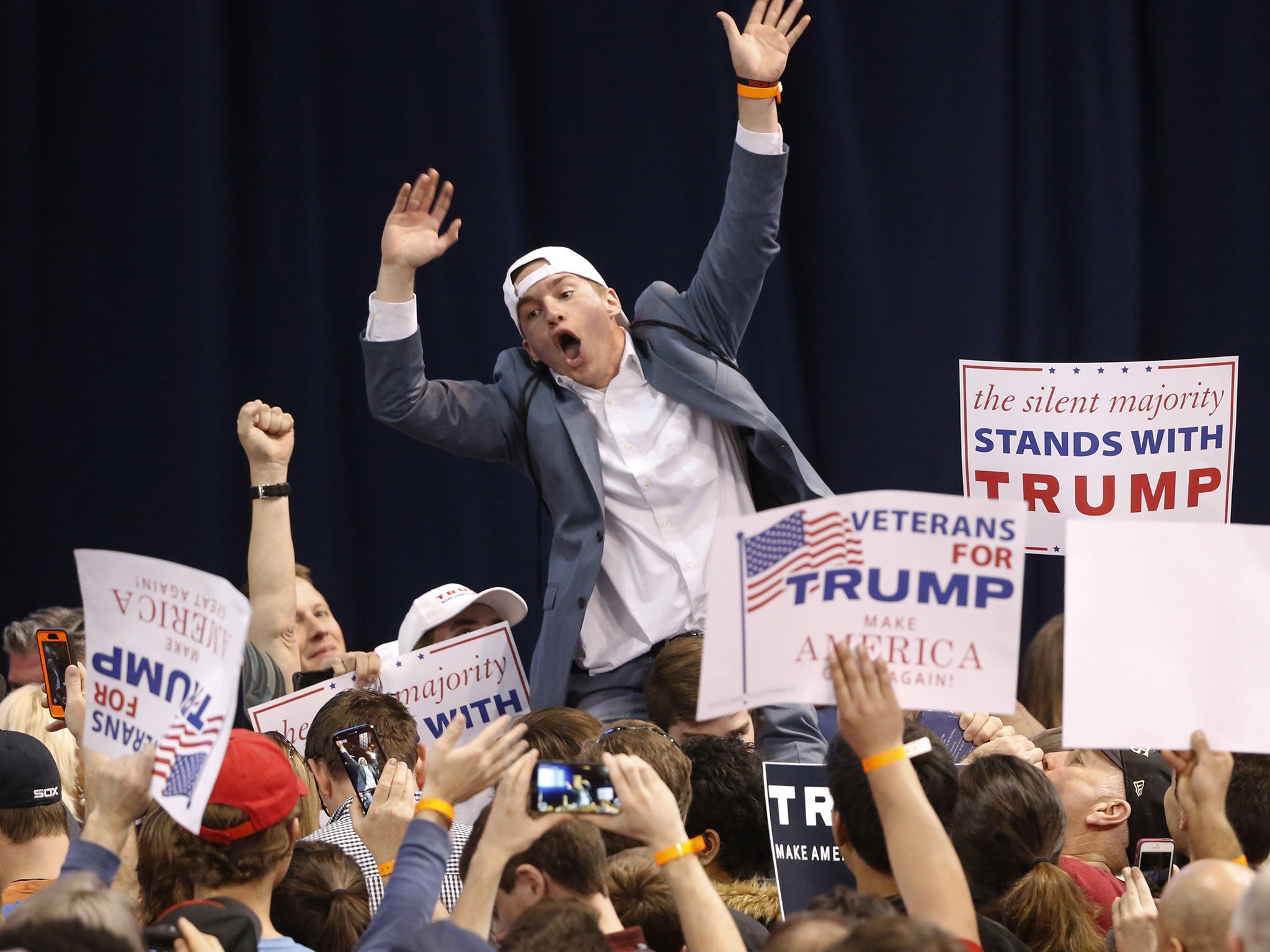A supporter of Republican presidential candidate Donald Trump tries to pump up the crowd before a rally on the campus of the University of Illinois-Chicago, Friday, March 11, 2016