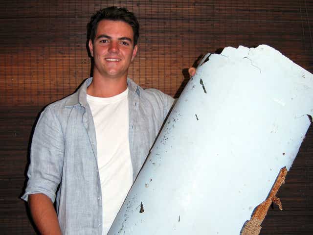 Liam Lotter poses with a piece of debris thought to be part of the missing Malaysia Airlines Flight MH370