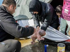 Refugee mother forced to wash newborn baby in a puddle at Greek camp
