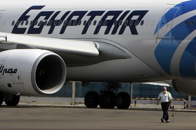 (File photo) An airport staff walks next to an EgyptAir plane on the runway at Cairo Airport