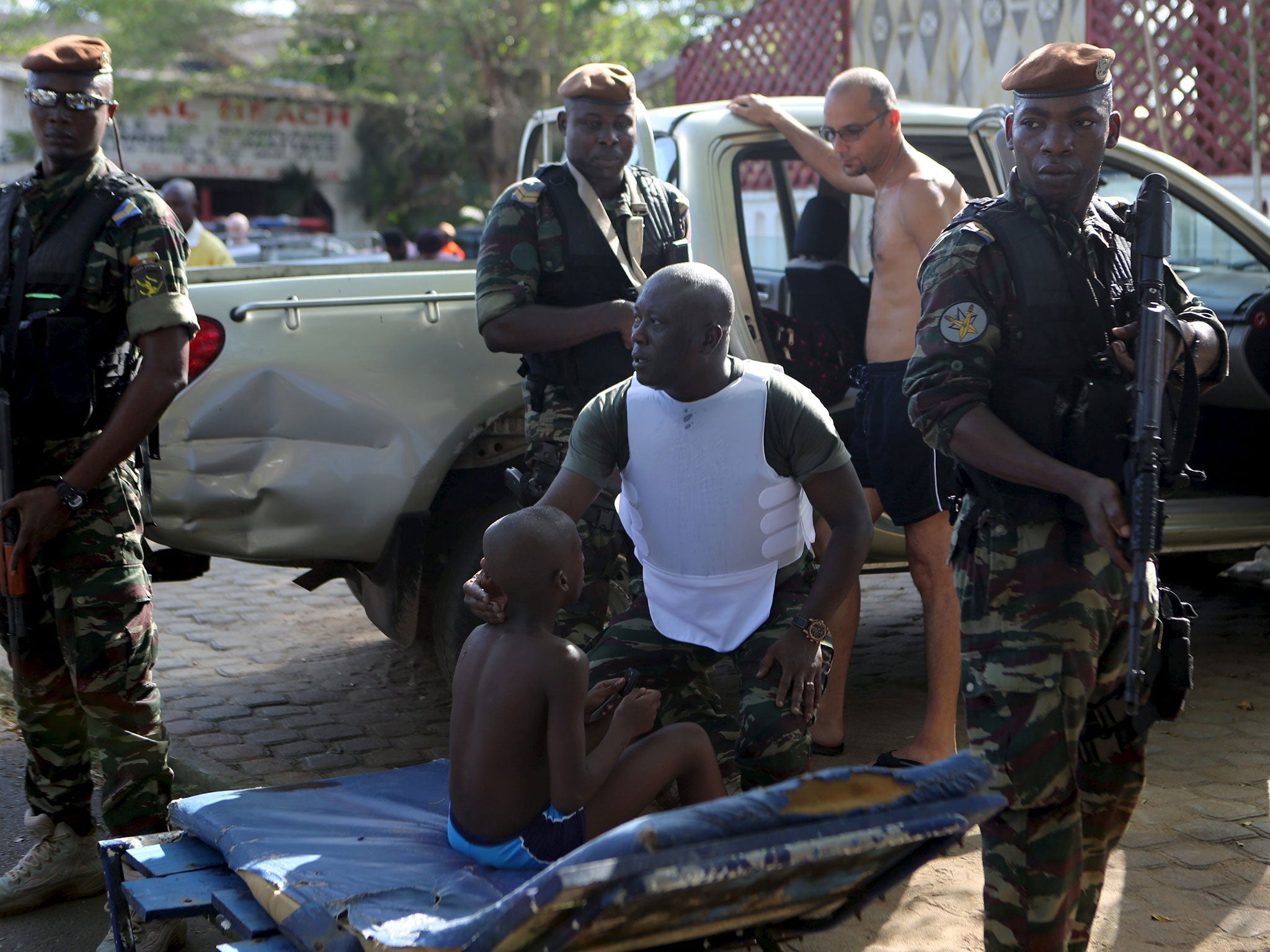 A soldier comforts an injured boy in Bassam, Ivory Coast