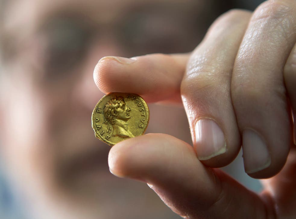 Dr. Donald Ariel of the Israeli Antiquities Authority displays an extremely rare 24-karat gold coin showing the Roman Emperor Augustus and dated to almost 2,000 years ago in the Israel Museum in Jerusalem