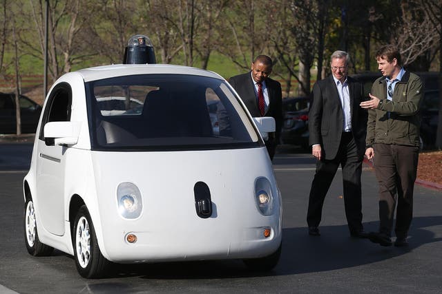 US transport secretary Anthony Foxx (L) and Google chairman Eric Schmidt (C) are shown a Google self-driving car by engineer Chris Urmson