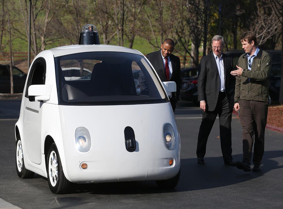 US transport secretary Anthony Foxx (L) and Google chairman Eric Schmidt (C) are shown a Google self-driving car by engineer Chris Urmson