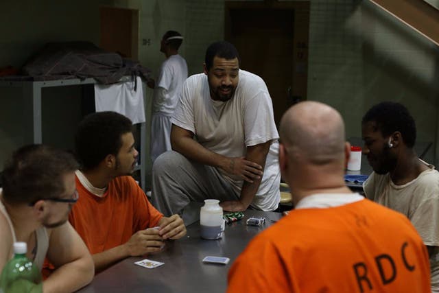 Zac (left) and Isaiah (right), two undercover participants on "60 Days In," sit among a group of inmates